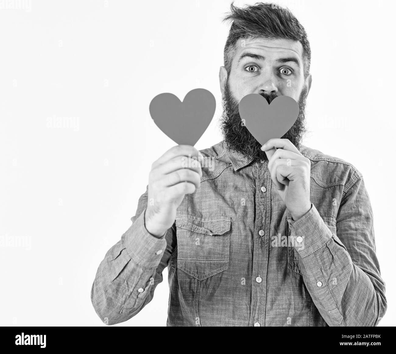 Hipster in Liebe feiert Valentinstag oder sendet Valentinskarten, auf weißem Hintergrund. Mann mit Bart mit überraschten Gesicht hält rotes Papier Herzen, kopieren. Valentines Tag und liebe Konzept Stockfoto