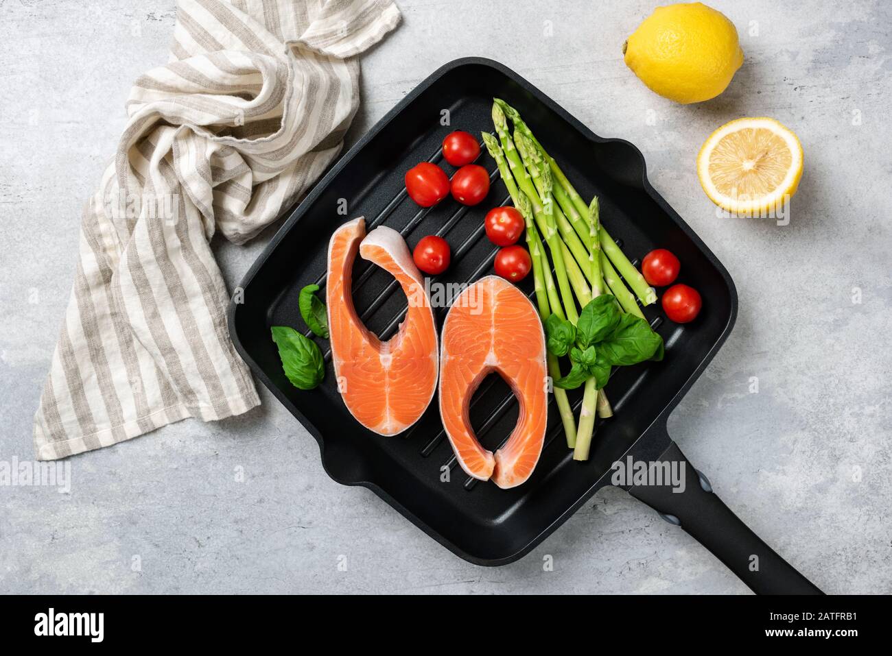 Lachssteaks, Asparagus Und Gemüse Auf EINER Grillpfanne. Unbehacktes Fischsteak Und Gemüse. Kochvorgang Stockfoto