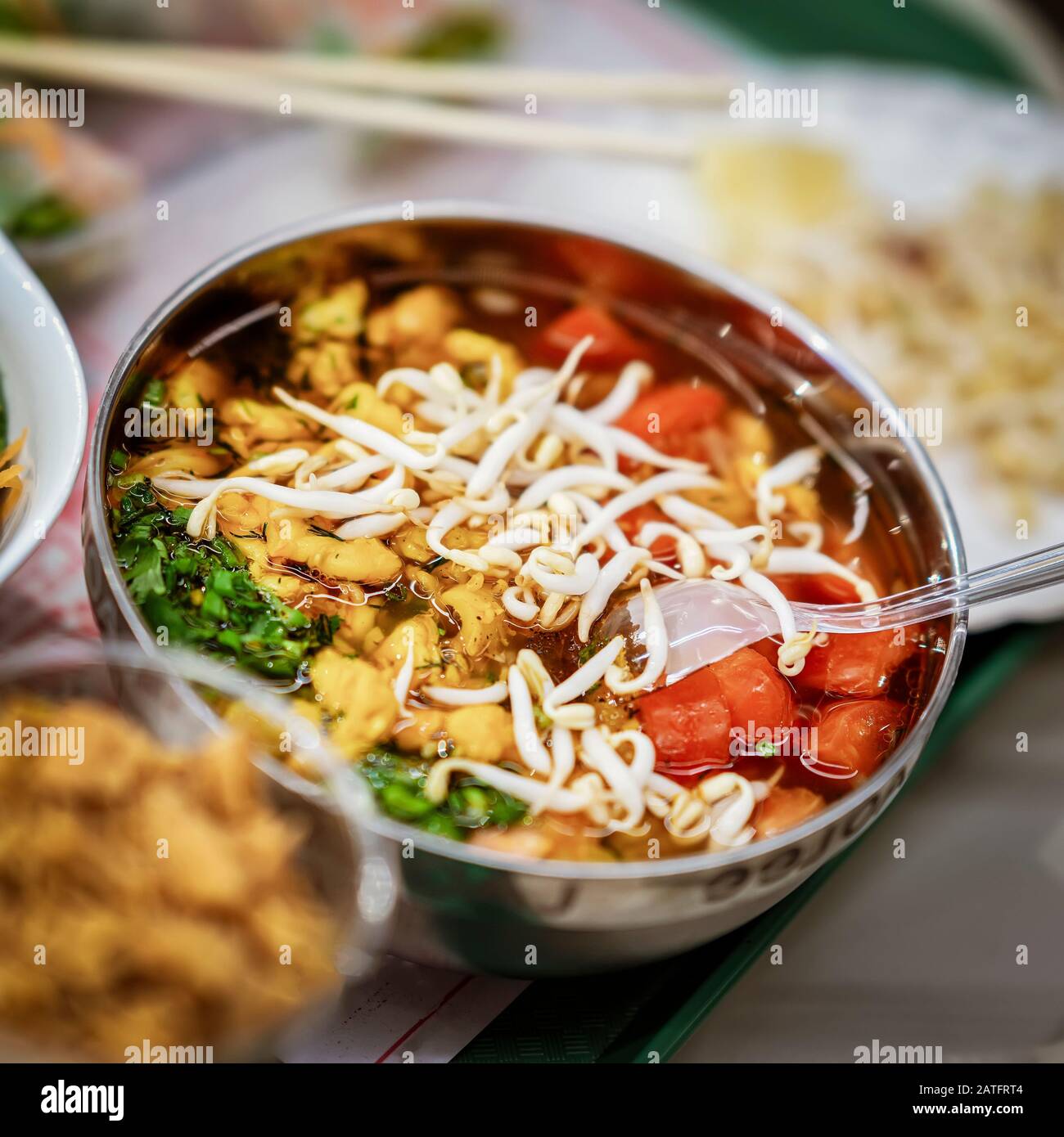 Asiatische Küche, würzige Suppe mit Gemüse, Meeresfrüchten und gereimten Sojasprossen in einer Schüssel-Nahaufnahme, Draufsicht. Selektiver Fokus Stockfoto