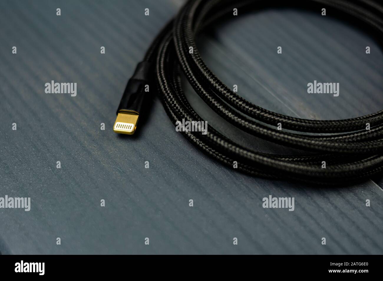 Schwarzes Geflechtstoffkabel mit Ligthennklemme zum Anschluss elektronischer Geräte Stockfoto