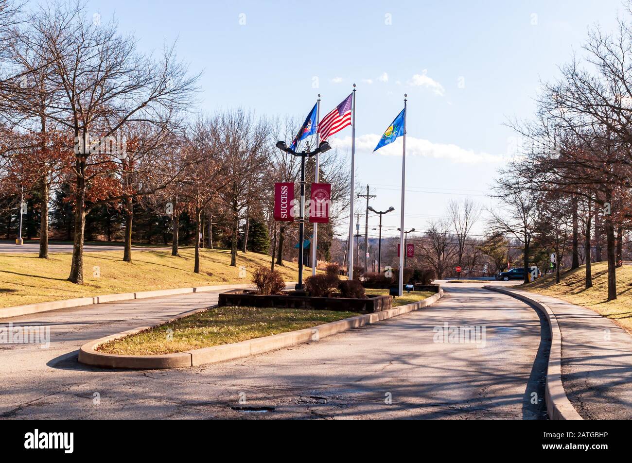 Die Flaggen am Eingang zum Boyce Campus des Community College von Allegheny County an einem sonnigen Wintertag, Monroeville, Pennsylvania, USA Stockfoto