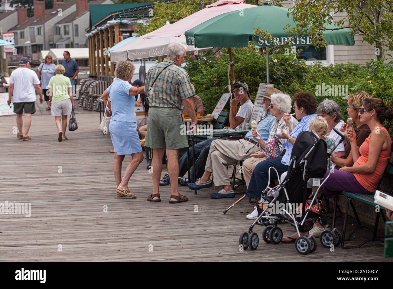 Touristen, die am Wasser sitzen und den Sommer im Camden Harbour, Maine, genießen Stockfoto