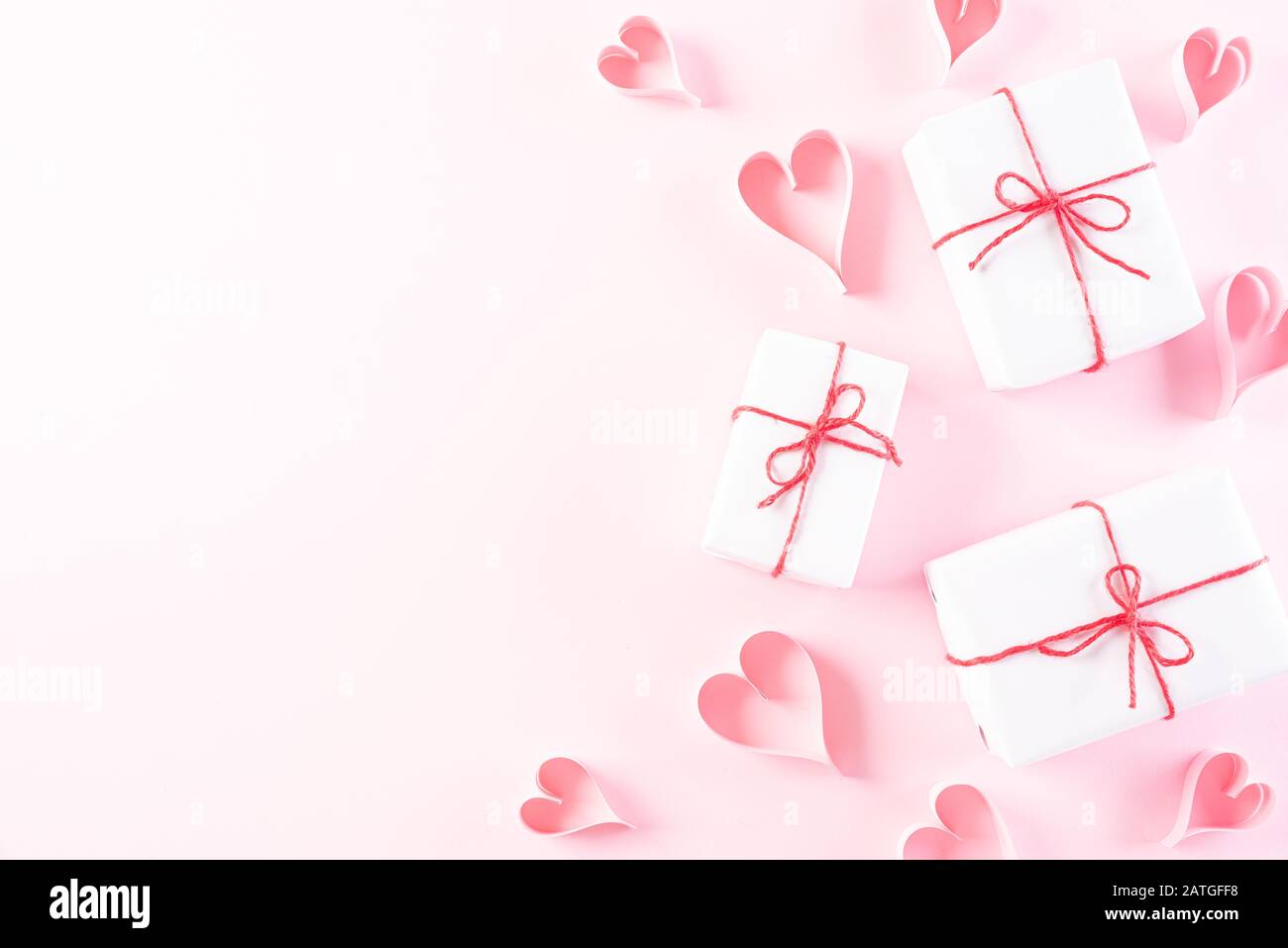 Rosa Papier Herzen mit Geschenkbox auf Hellrosa Pastellpapier Hintergrund. Liebe und Valentinstag Konzept. Stockfoto