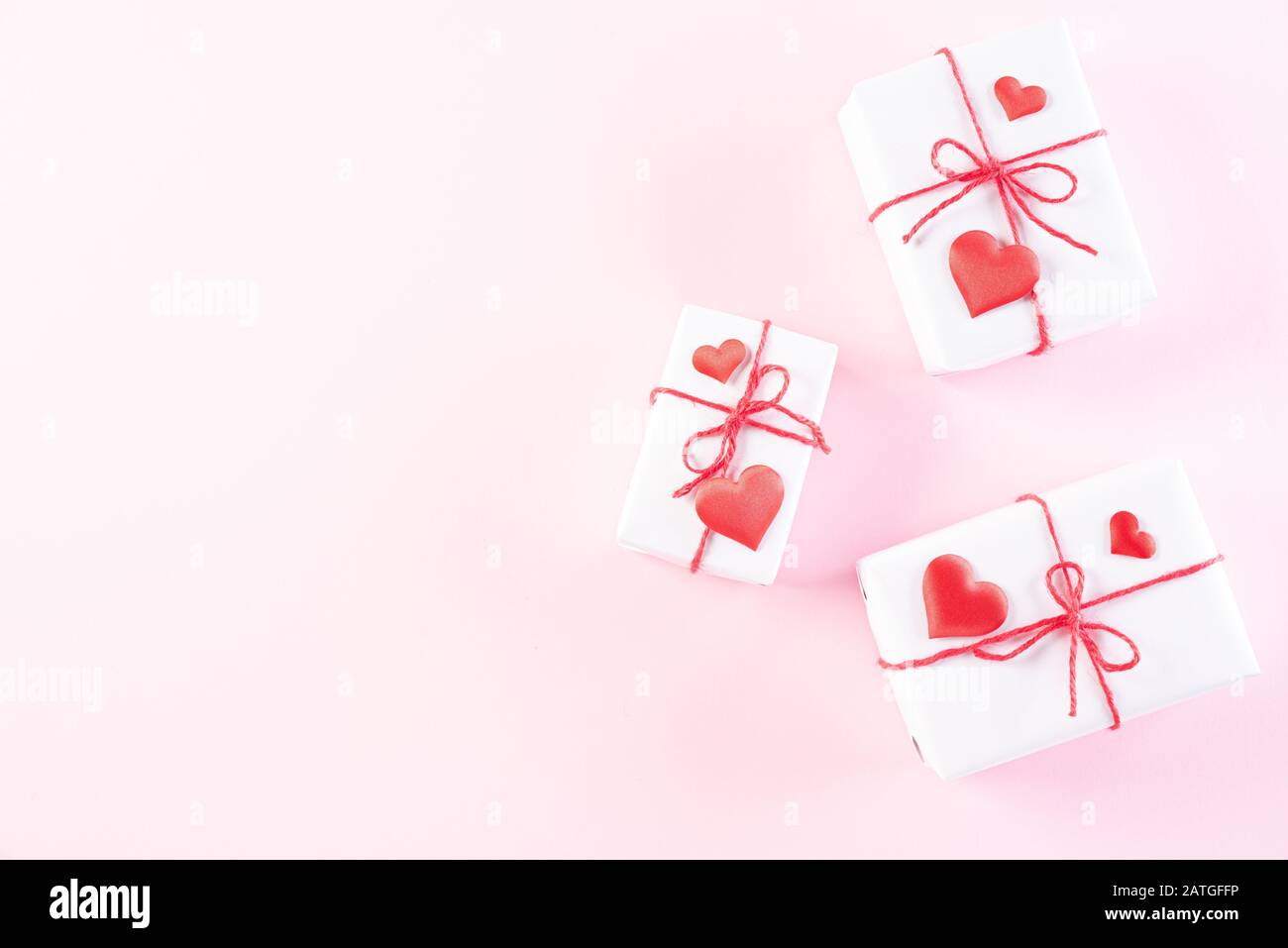 Rosa Papier Herzen mit Geschenkbox auf Hellrosa Pastellpapier Hintergrund. Liebe und Valentinstag Konzept. Stockfoto