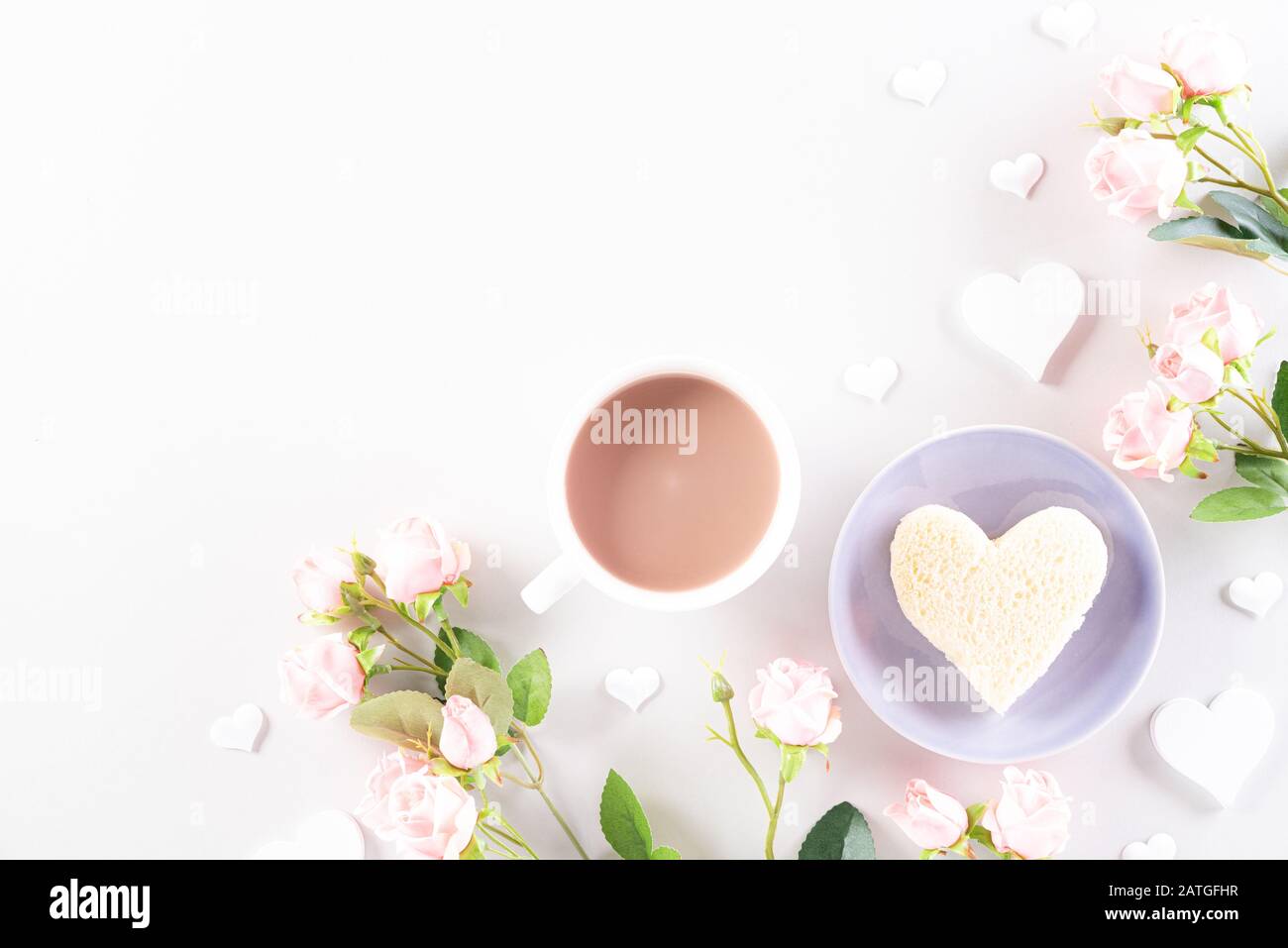 Rosa Papierherzen mit Geschenkbox, Kaffee und Rosen auf Hellrosa Pastellpapier Hintergrund. Liebe und Valentinstag Konzept. Stockfoto