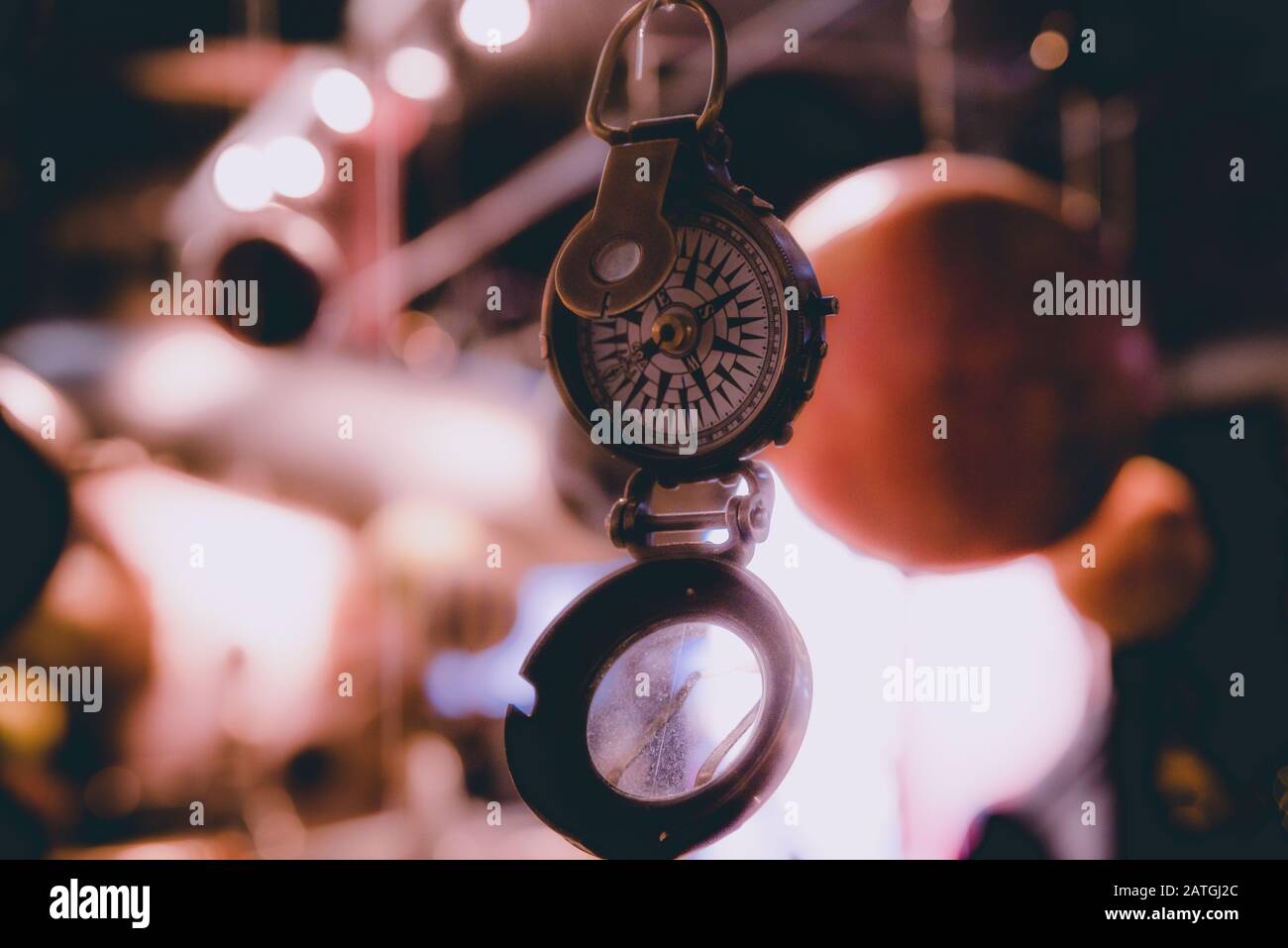 Schönes Bokeh eines Kompass hängen mit Lichtern und Überlegungen in den Hintergrund. Konzept verloren zu gehen, Freiheit und Streben nach Glück. Stockfoto