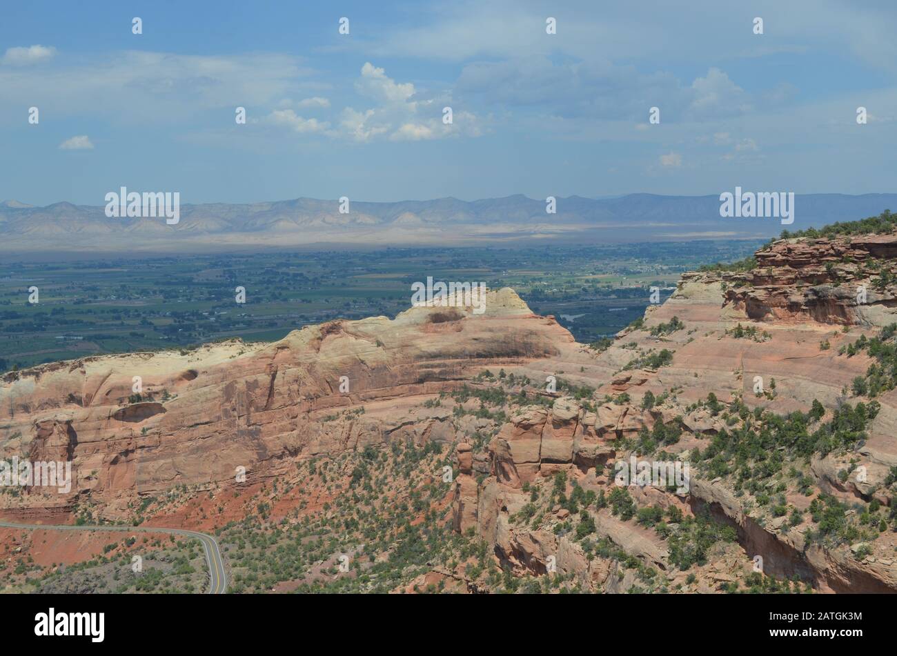 Sommer im Colorado National Monument: Blick Über Rim Rock Drive und Fruita Canyon zum Grand Valley und die Book Cliffs vom Fruita Canyon View Stockfoto