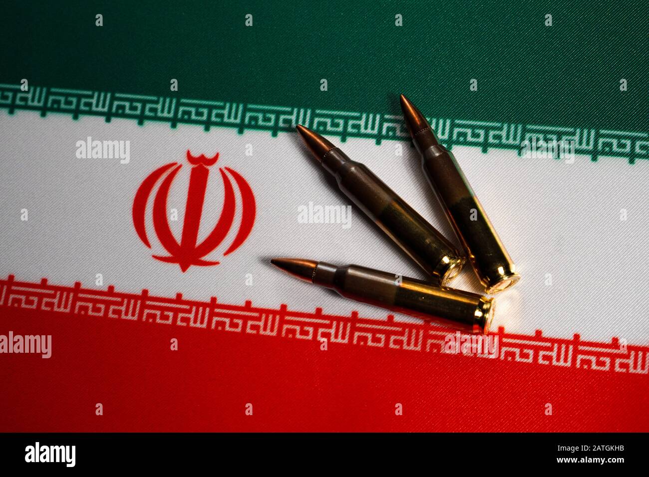 Drei Gewehrpatronen auf der Flagge des Iran. Nahaufnahme, Kopierbereich Stockfoto