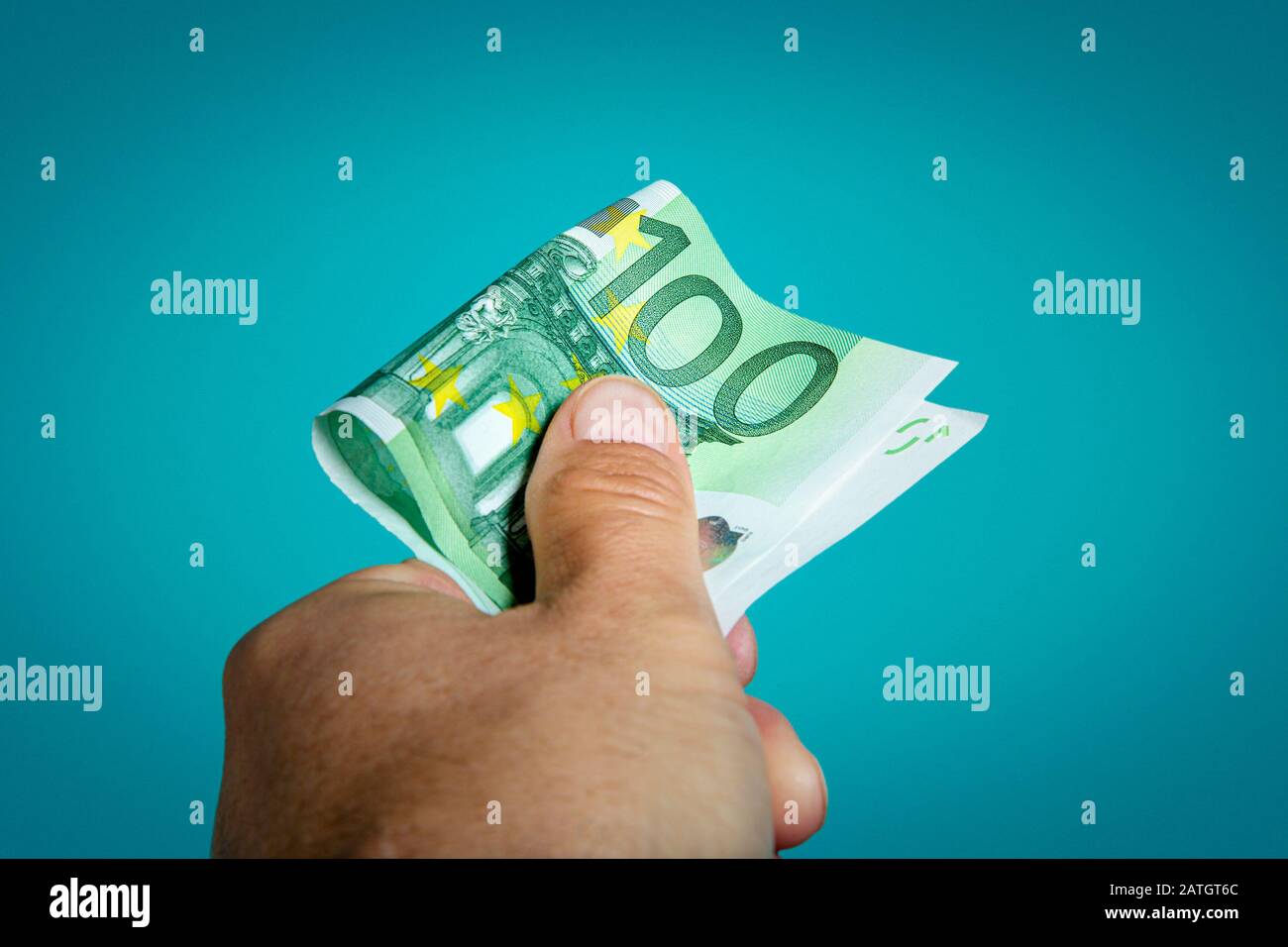 Nahaufnahme der Person, die eine 100-Euro-Rechnung erreicht. Stockfoto
