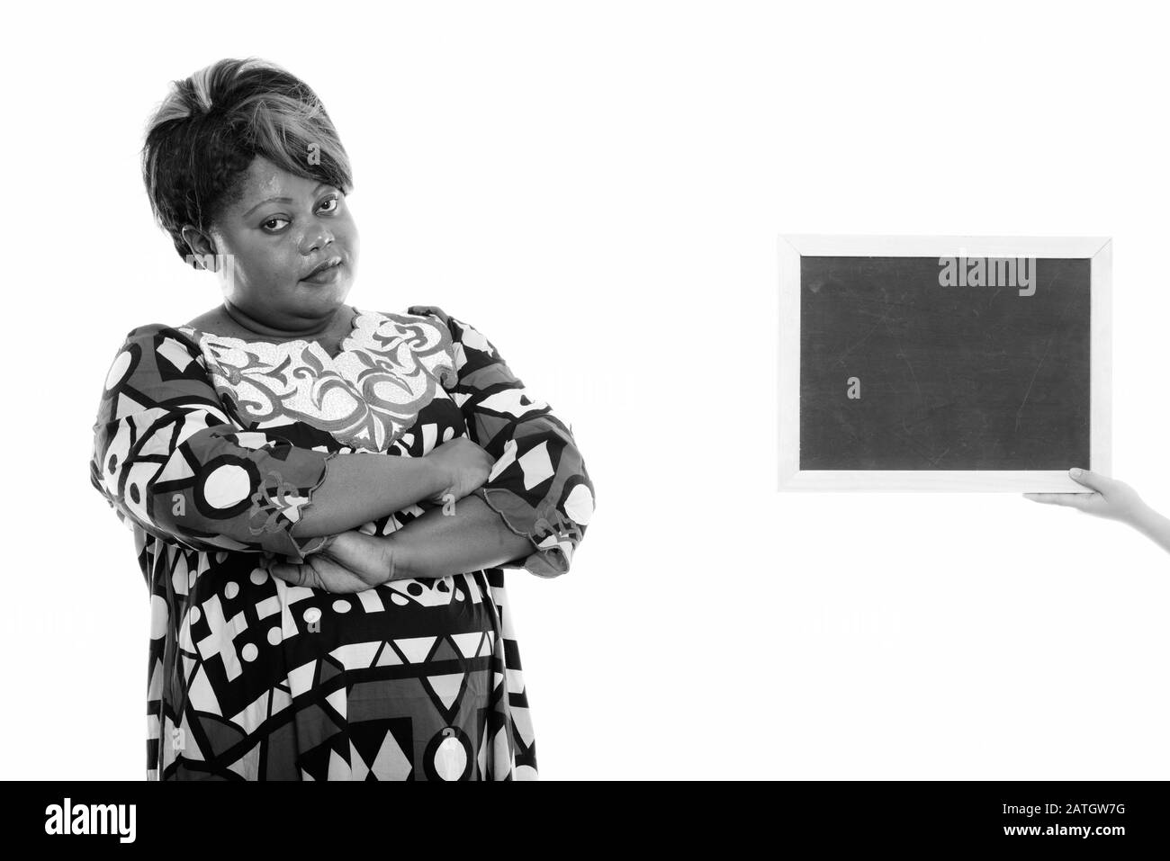 Studioaufnahme von fetter schwarzer Afrikanerin mit mit mit leerer Tafel gekreuzten Armen Stockfoto