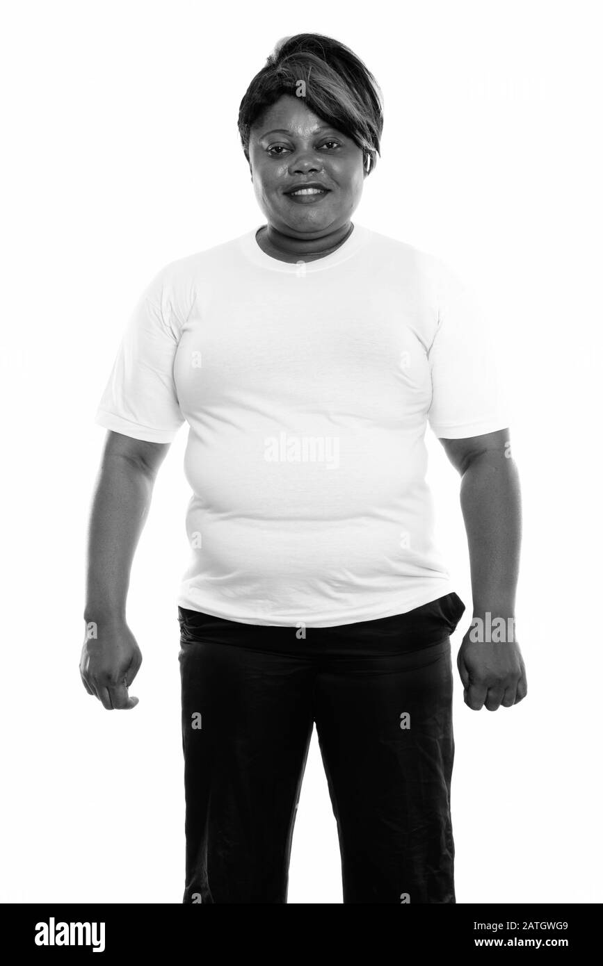 Studio-Schuss von fröhlicher, fettschwarzer Afrikanerin lächelt und steht bereit für die Sporthalle Stockfoto