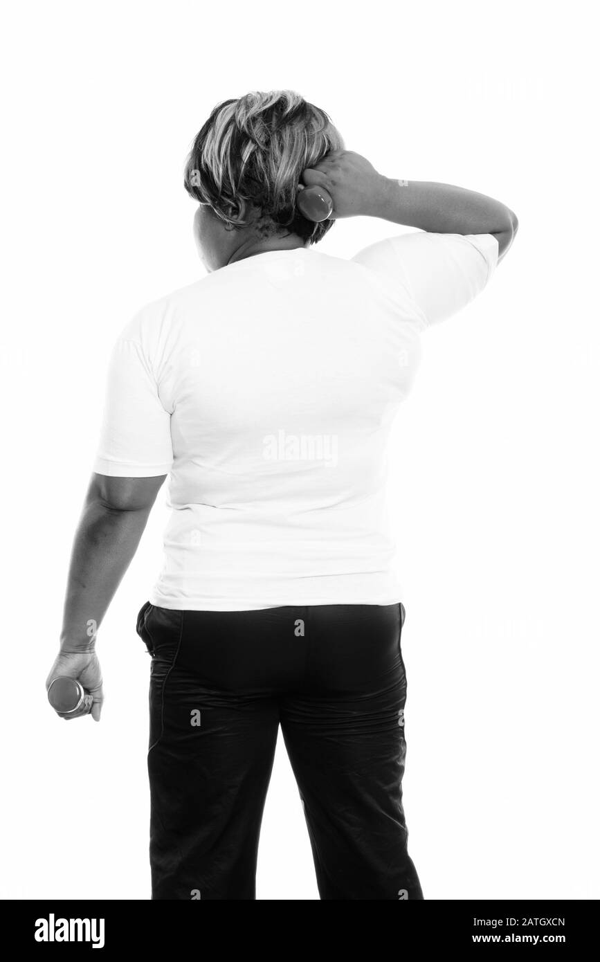 Rückansicht der fettschwarzen Afrikanerin, die mit Hanteln trainiert, die für das Fitnessstudio bereit sind Stockfoto