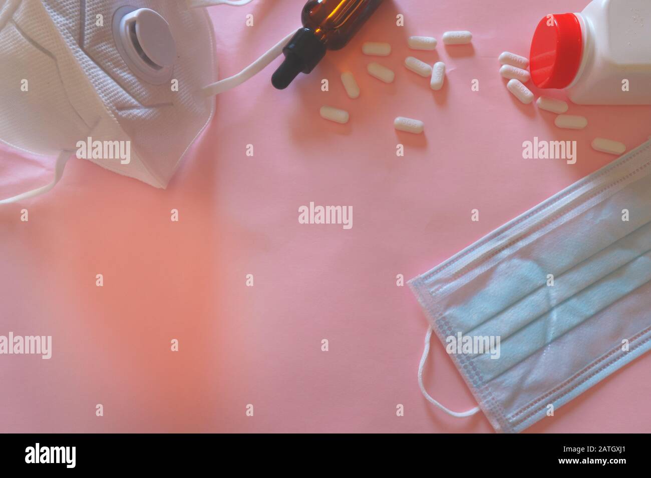 Medizinische Maske und Vitamin-C-Pillen auf pinkfarbenem Hintergrund, um das Konzept der Infektionskontrolle, des neuartigen Coronavirus (2019-nCoV)-Ausbruchs und der globalen Heilung zu zeigen Stockfoto