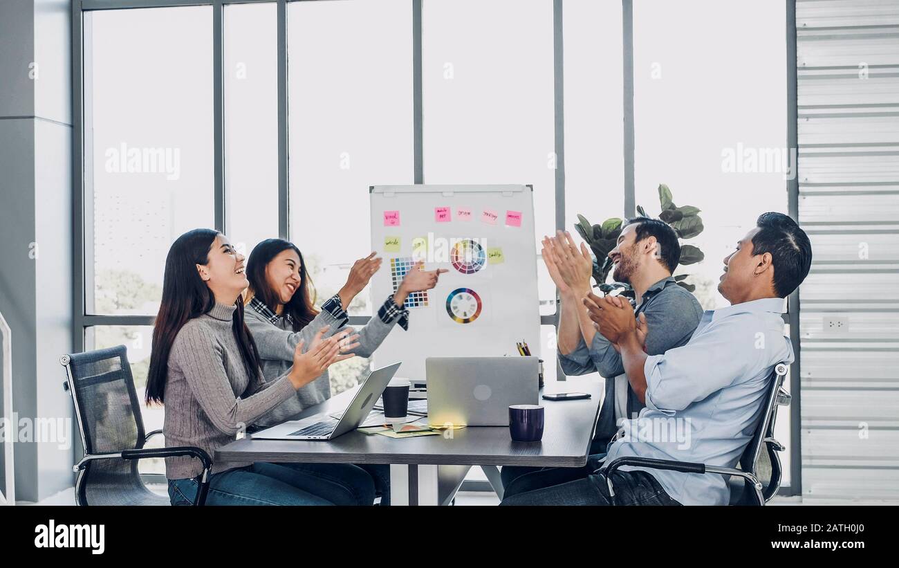 Vielfalt kreativer Designer applaudieren für Job Erfolg am Konferenztisch im modernen Büro nach Beenden der Präsentation zu Client. teamwork Konzept Stockfoto