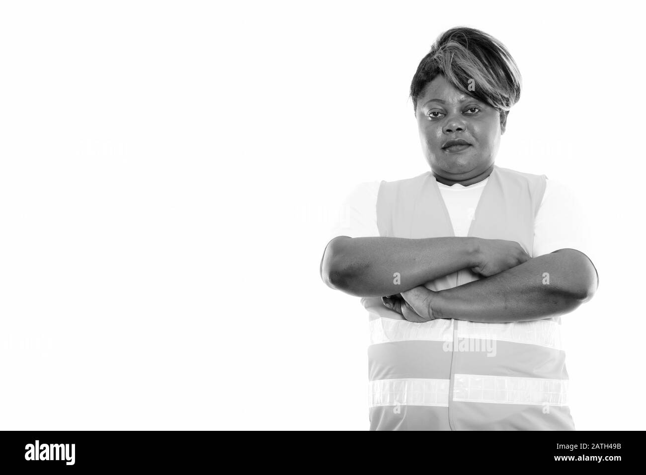 Studioaufnahme der fettschwarzen Afrikanerin, Bauarbeiterin mit gekreuzten Armen Stockfoto