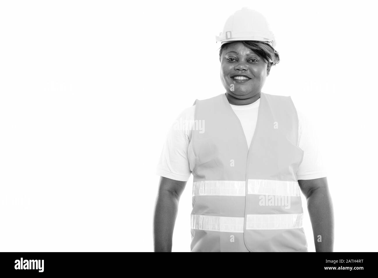 Studioaufnahme der fröhlichen, fettschwarzen afrikanischen Bauarbeiterin lächelnd Stockfoto
