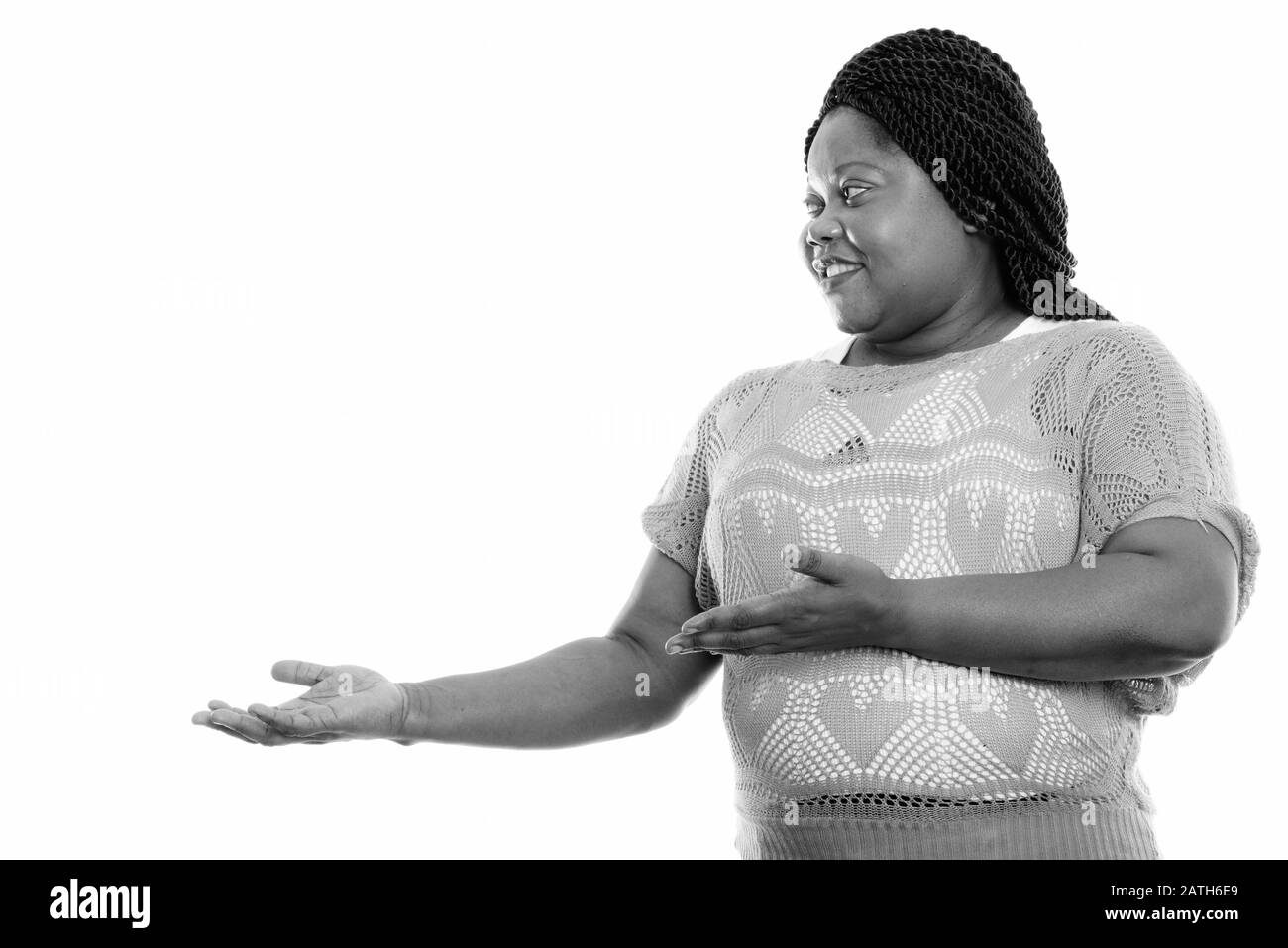 Profilansicht der fröhlichen schwarzen Afrikanerin lächelt, während sie etwas zeigt Stockfoto