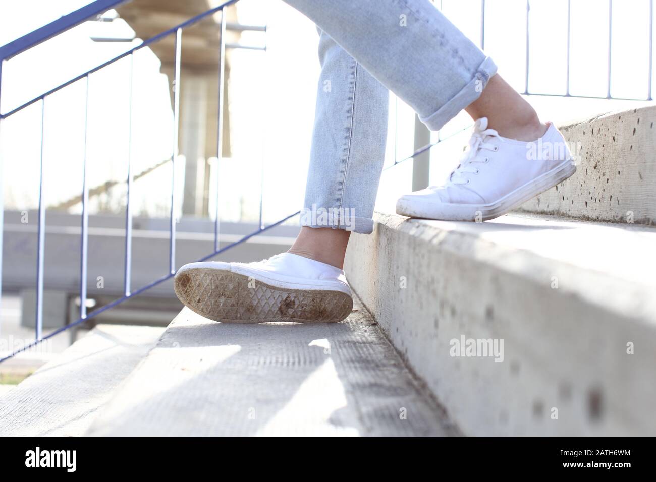 Nahaufnahme des Porträts der Beine des Mädchens mit Turnschuhen, die die Treppe hinuntergehen und den Knöchel verstauen Stockfoto