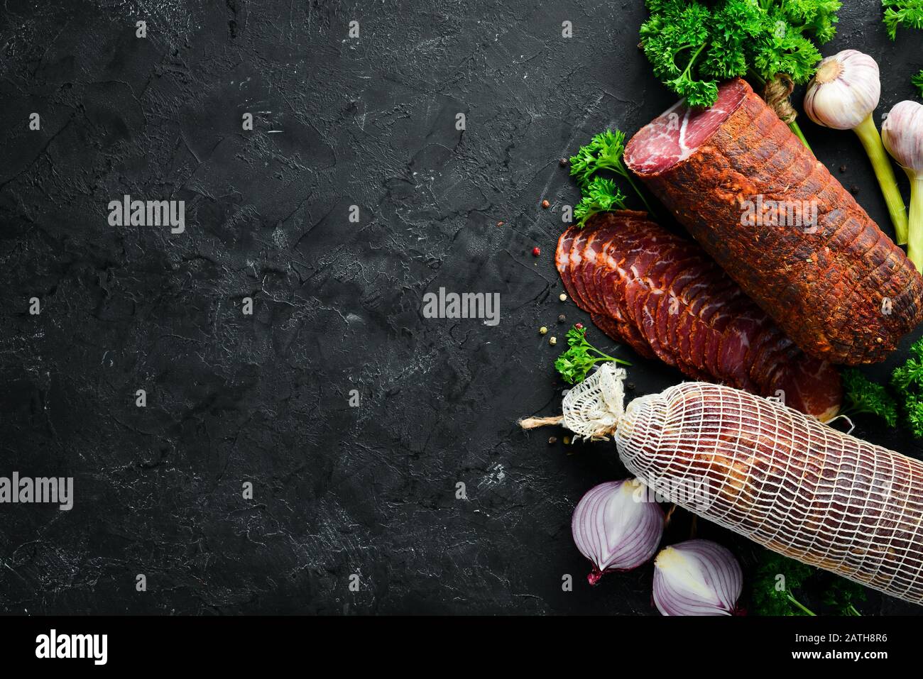 Getrocknetes Kalbsfleisch mit Gewürzen und Kräutern. Rindfleisch auf altem schwarzen Tisch ruckartig. Draufsicht. Freier Speicherplatz für Ihren Text. Stockfoto