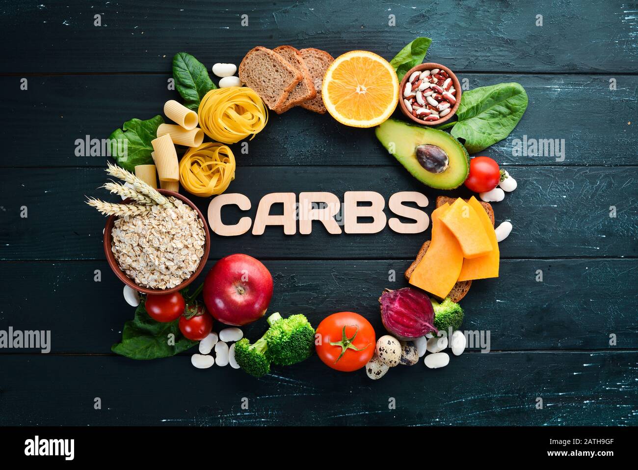 Kohlenhydratreiche Lebensmittel: Brot, Pasta, Avocado, Mehl, Kürbis, Brokkoli, Bohnen, Spinat. Das Konzept des gesunden Essens. Auf schwarzem Hintergrund. Stockfoto