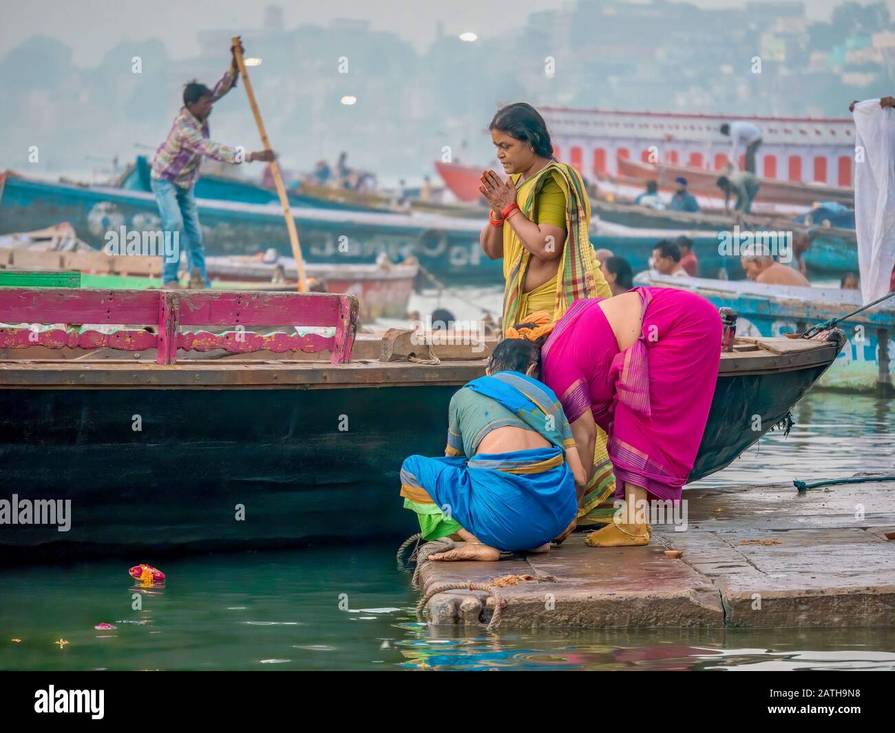 Varanasi, Indien - 12. November 2015. Drei indische Hindu-Frauen, die traditionelle Saris tragen, beten und entzünden Kerzen am Fluss Ganges, während Diwali. Stockfoto