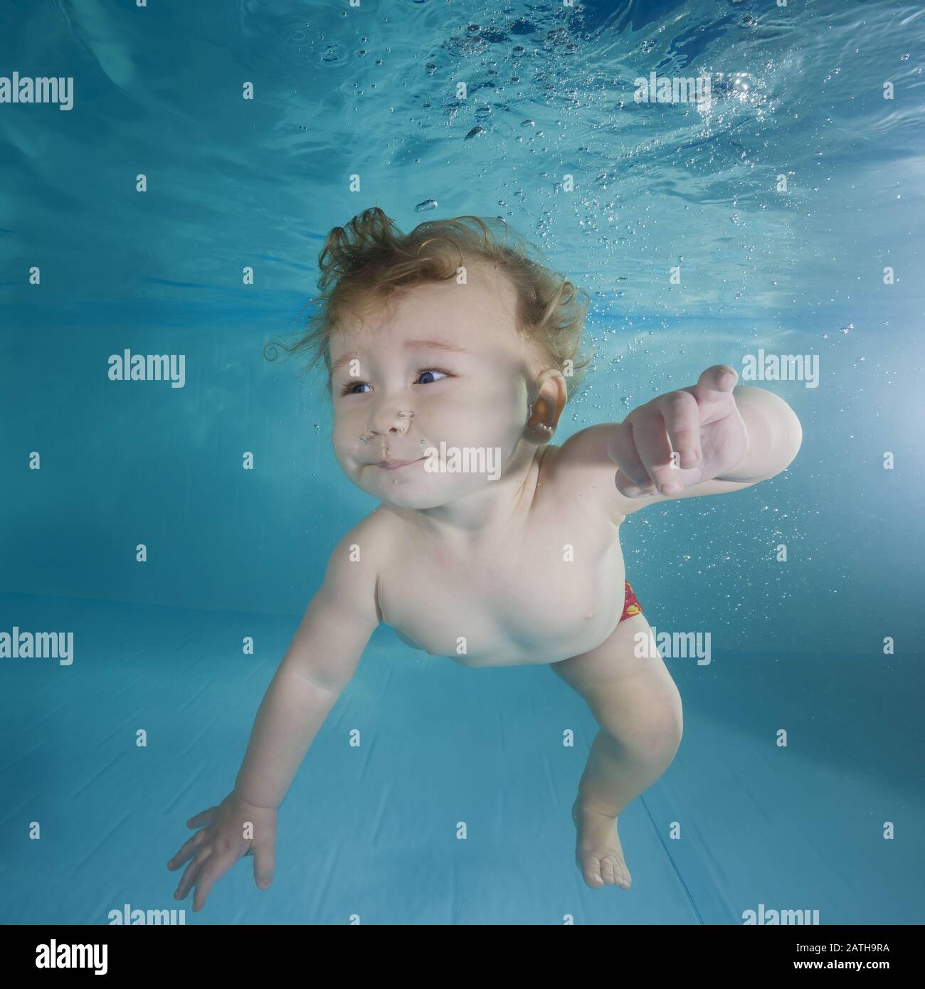 Lustiger rothaariger Junge spielt unter Wasser in einem Schwimmbad Stockfoto