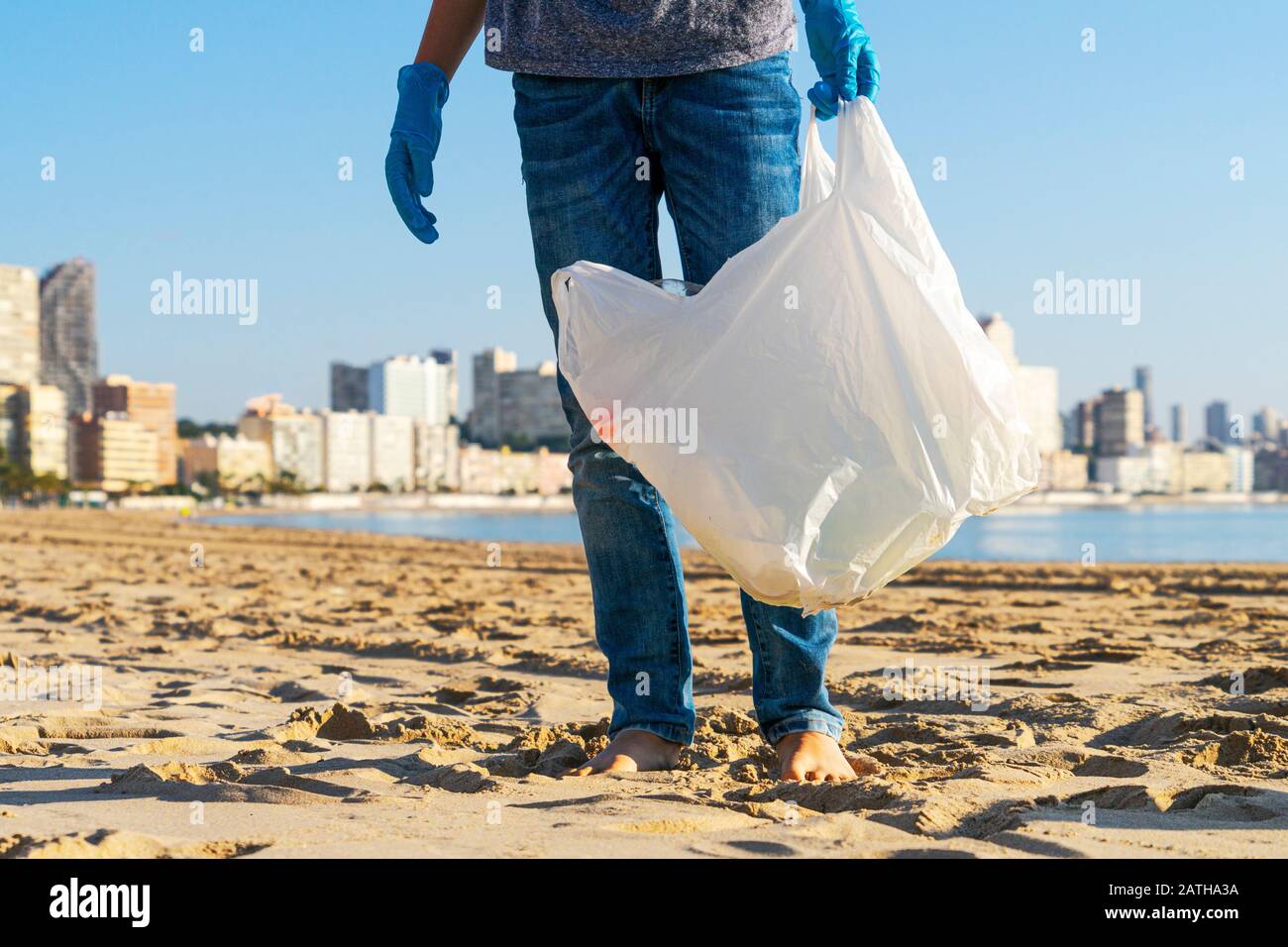 Sauberer Strand aus Kunststoff. Freiwillige holen Plastikflasche Müll vom Strand und in Plastiktüte zum Recycling Stockfoto