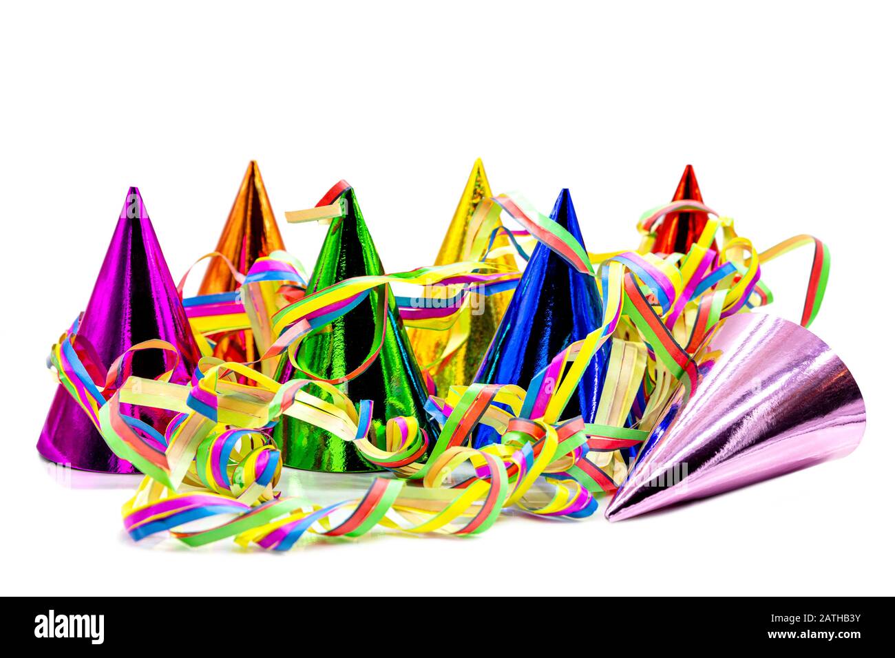 Bunte Partyhüte und Papierstreifer isoliert auf weißem Hintergrund, Einladung zum Geburtstag oder Karneval Stockfoto