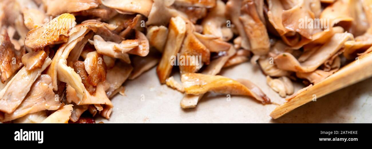 Kopfzeile, gerösteter rosafarbener Austernpilz in einer Küchenpfanne, Feinschmeckerrestaurant, Nahaufnahme Stockfoto