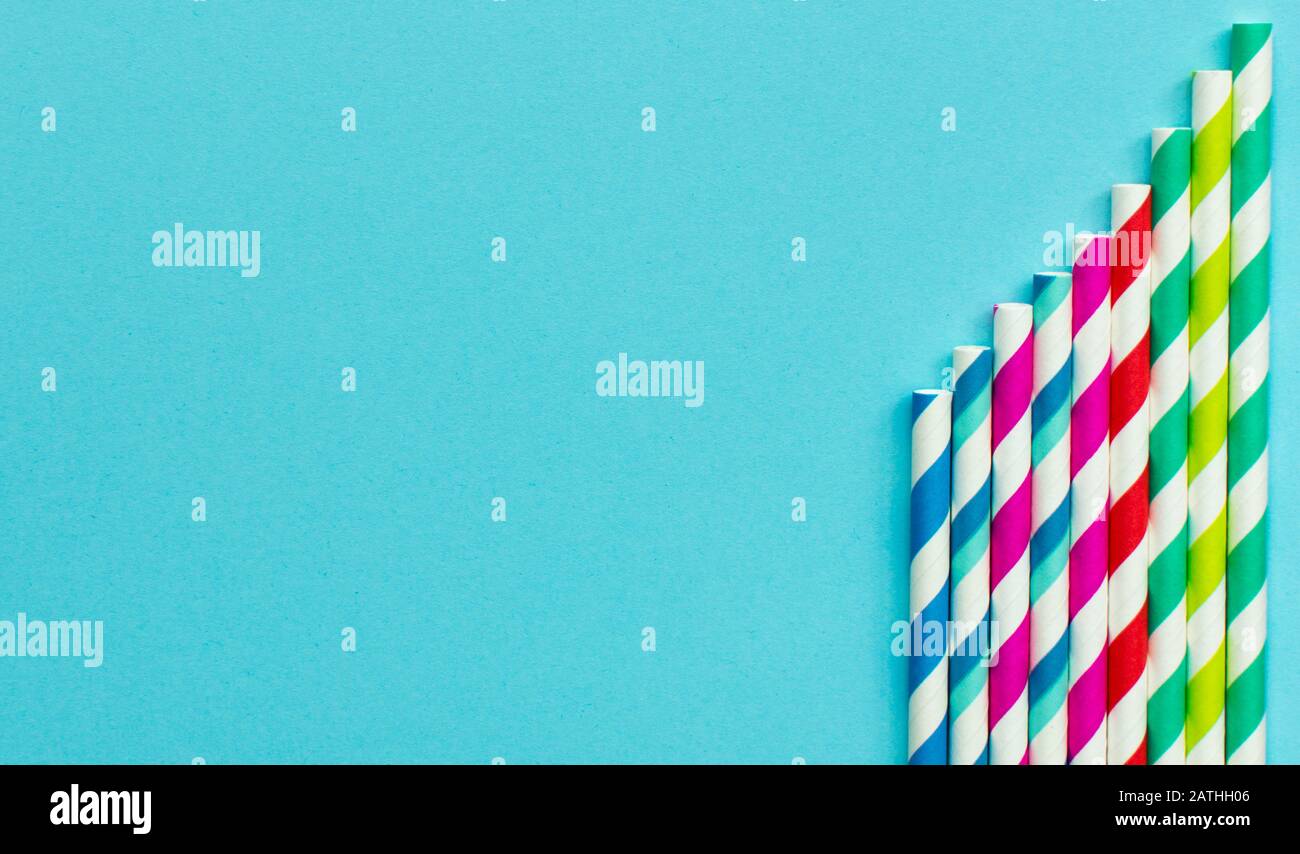 Gestrippte Papierstrathalme auf blauem Hintergrund Stockfoto