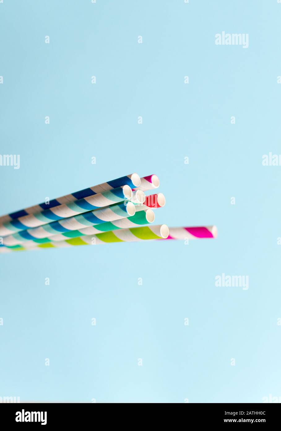 Gestreifte mehrfarbige Papierhalme im Retro-Stil auf blauem Hintergrund Stockfoto