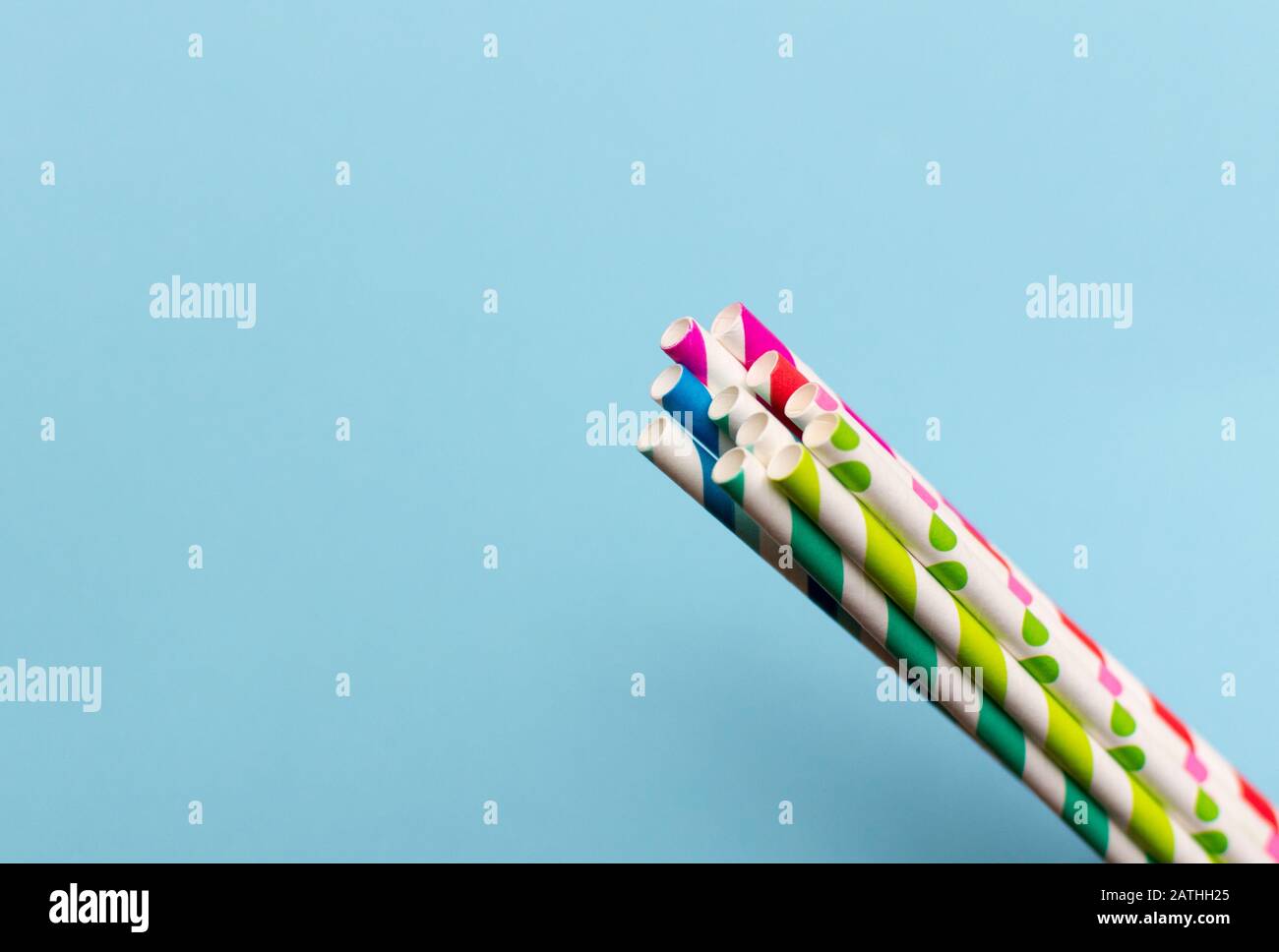 Gestreifte mehrfarbige Papierhalme im Retro-Stil auf blauem Hintergrund Stockfoto
