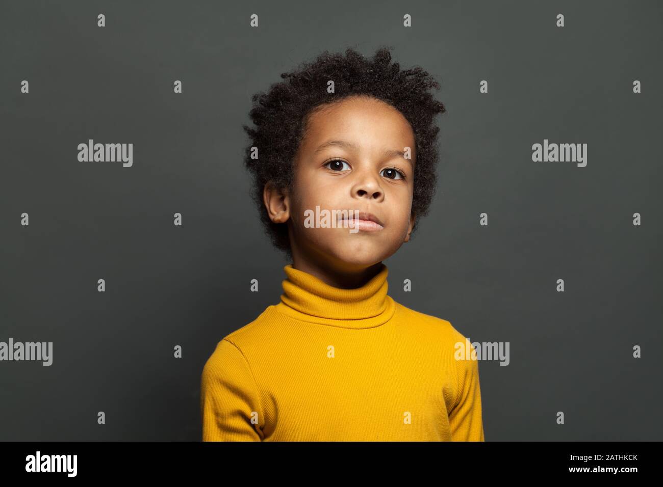 Kleines Kinderporträt. Kleiner afroamerikanischer Junge auf grauem Hintergrund Stockfoto