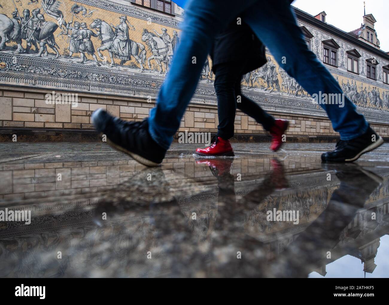 Dresden, Deutschland. Februar 2020. Touristen gehen durch eine Pfütze auf dem Fürstenzug im Regen. Credit: Dpa Picture Alliance / Alamy Live News Stockfoto