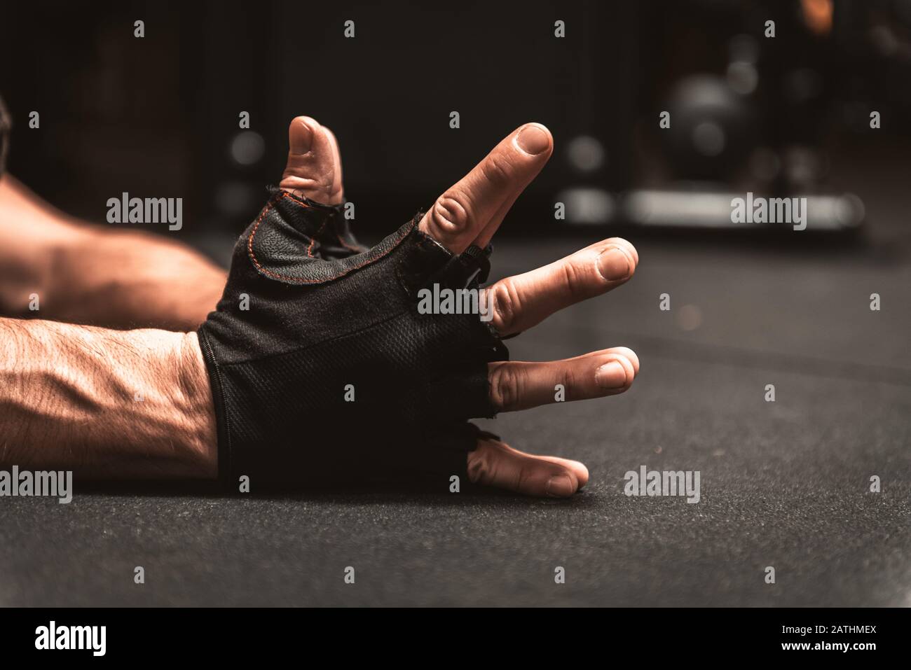 Die Hände im Vordergrund eines Mannes. Hände mit schwarzen fingerlosen Handschuhen für den sportlichen Einsatz. Nahaufnahme der Hände des Mannes in schwarzen Handschuhen ohne Finger in einem Nam Stockfoto
