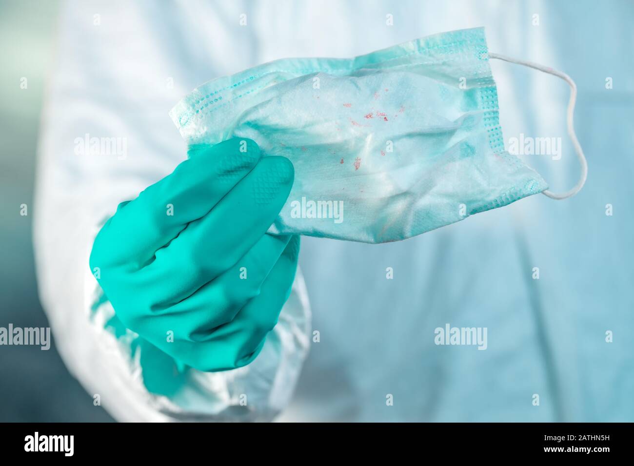 Epidemiologe, der Atemmaske mit Blutflecken im wuhan Coronavirus Konzept hält Stockfoto