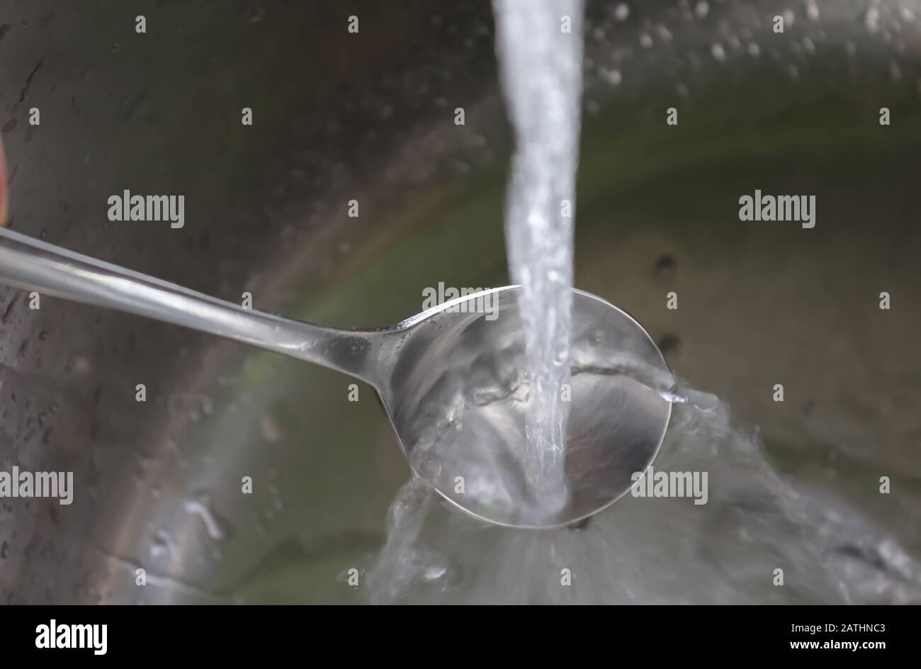 Fließendes Wasser aus einem Wasserhahn in einem metallischen Küchenwaschbecken Stockfoto