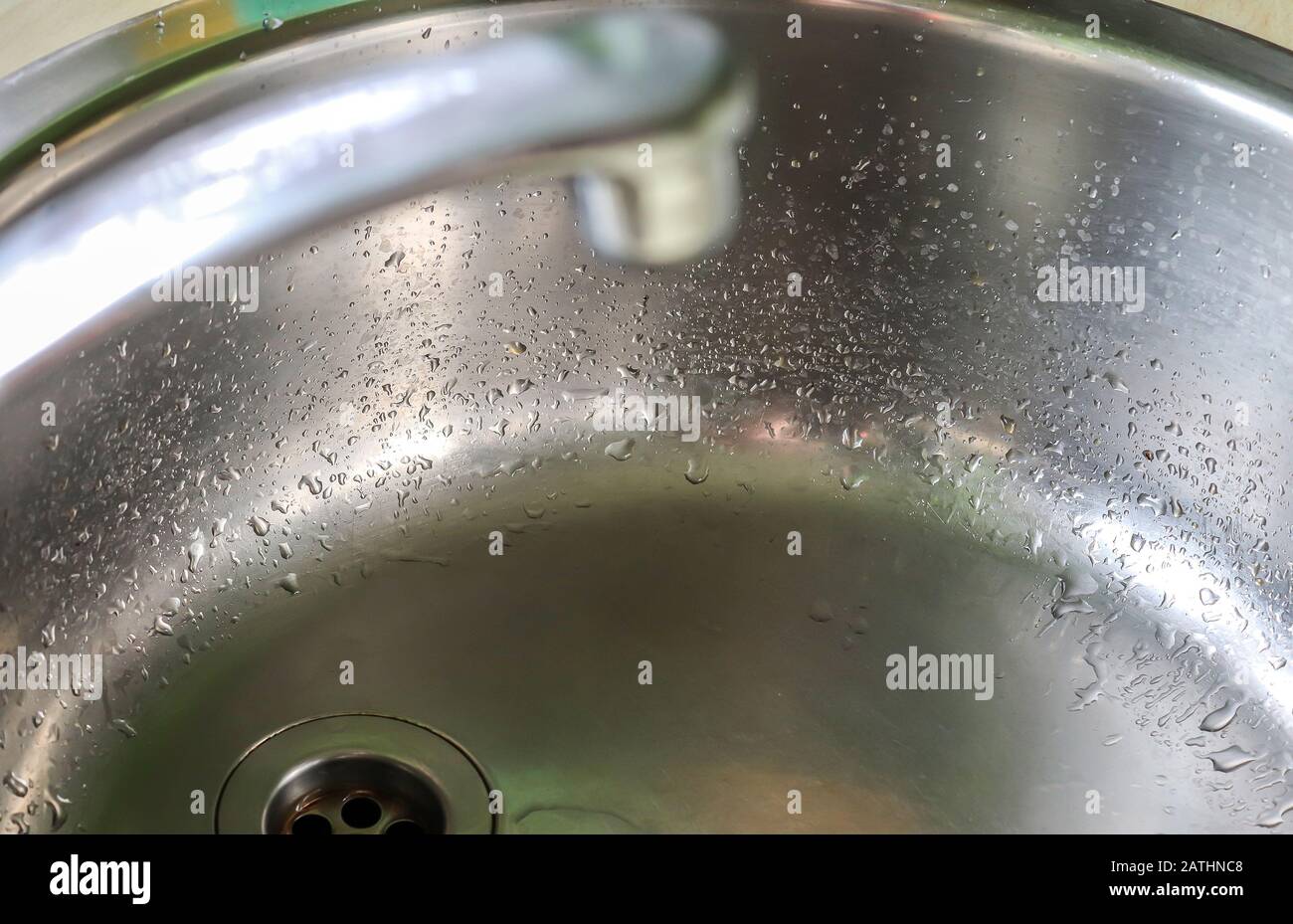 Fließendes Wasser aus einem Wasserhahn in einem metallischen Küchenwaschbecken Stockfoto