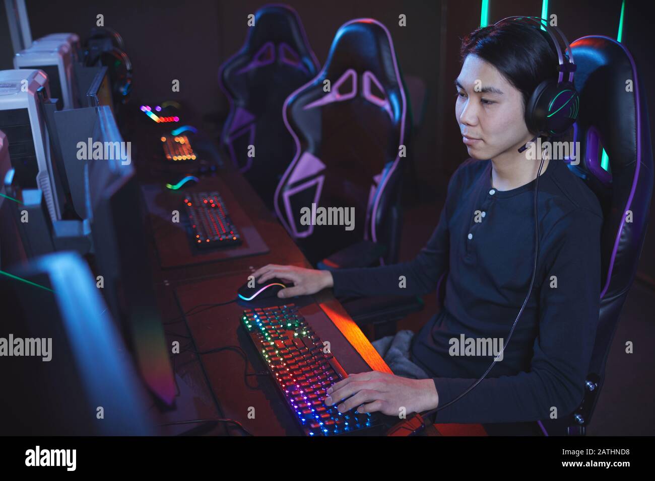 Hochwinkelporträt junger Asiaten, der Videospiele im Cyber-Sportstuhl spielt, Copy-Space Stockfoto
