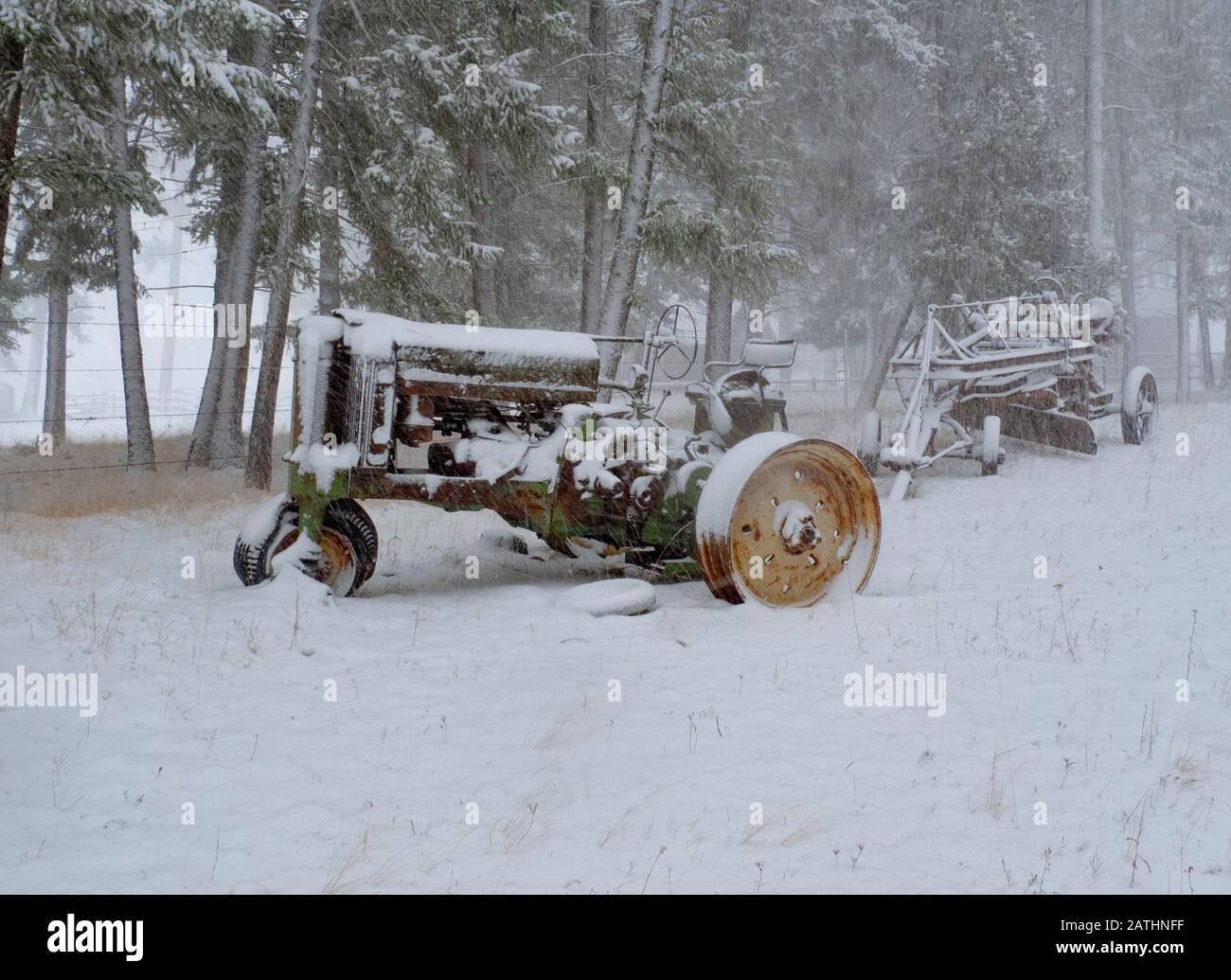Ein Traktor des Typs John Deere Model B aus dem Jahr 1940 in einem Schneesturm auf der Pferderanch in Valley of the Moon, Rock Creek, Montana Stockfoto