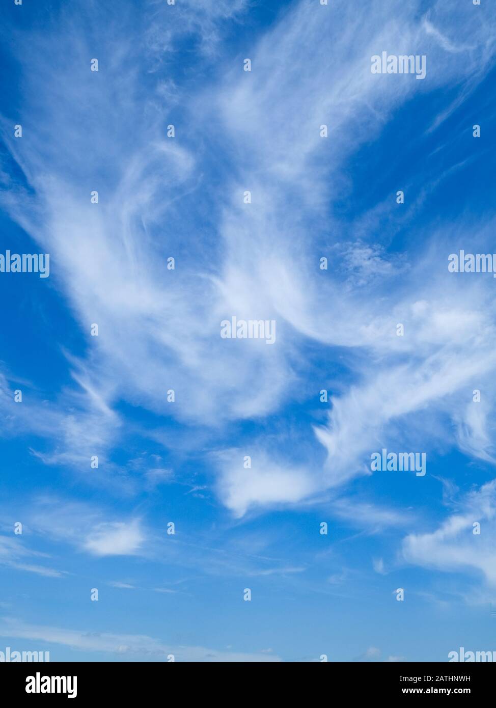Wispige weiße Wolkenbildung gegen einen leuchtend blauen Himmel. Perry Green, Much Hadham, Hertfordshire. GROSSBRITANNIEN Stockfoto