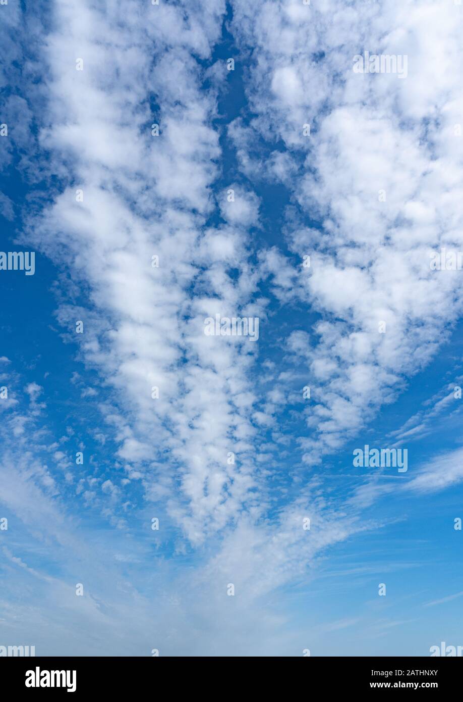 Wispige weiße Wolkenbildung gegen einen leuchtend blauen Himmel. Perry Green, Much Hadham, Hertfordshire. GROSSBRITANNIEN Stockfoto