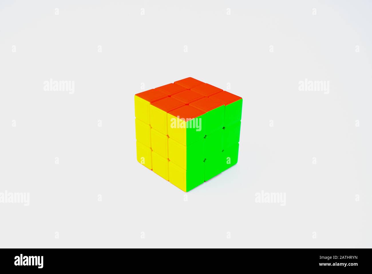Ein gelöster 3 x 3-Rubik-Würfel, isoliert in einem weißen Hintergrund, mit rot-grüner und gelber Farbe Stockfoto