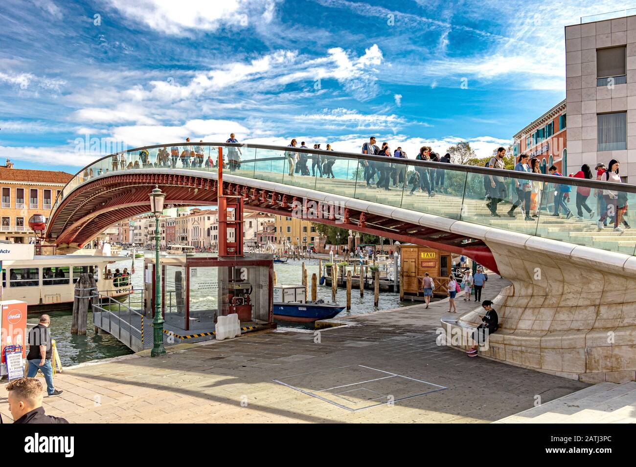 Menschen, die über Die Brücke Ponte delle Costituzione oder Constitution in Venedig spazieren, eine Brücke aus Glas und Stahl, die den Canal Grande, Venedig, überquert Stockfoto
