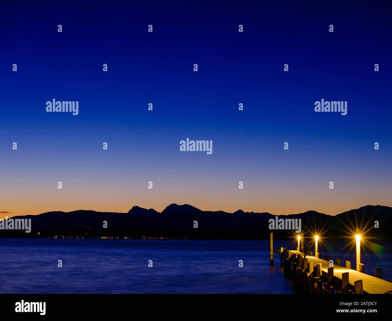 Fußgängerbrücke am Chiemsee im Morgengrauen hinter den Chiemgauer Alpen, Chiemgau, Oberbayern, Bayern, Deutschland Stockfoto