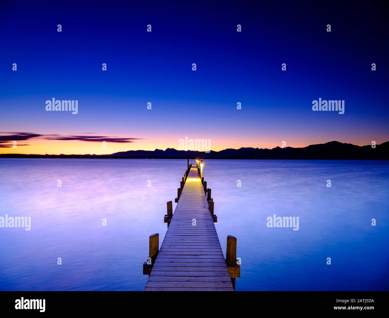 Fußgängerbrücke am Chiemsee im Morgengrauen hinter den Chiemgauer Alpen, Chiemgau, Oberbayern, Bayern, Deutschland Stockfoto