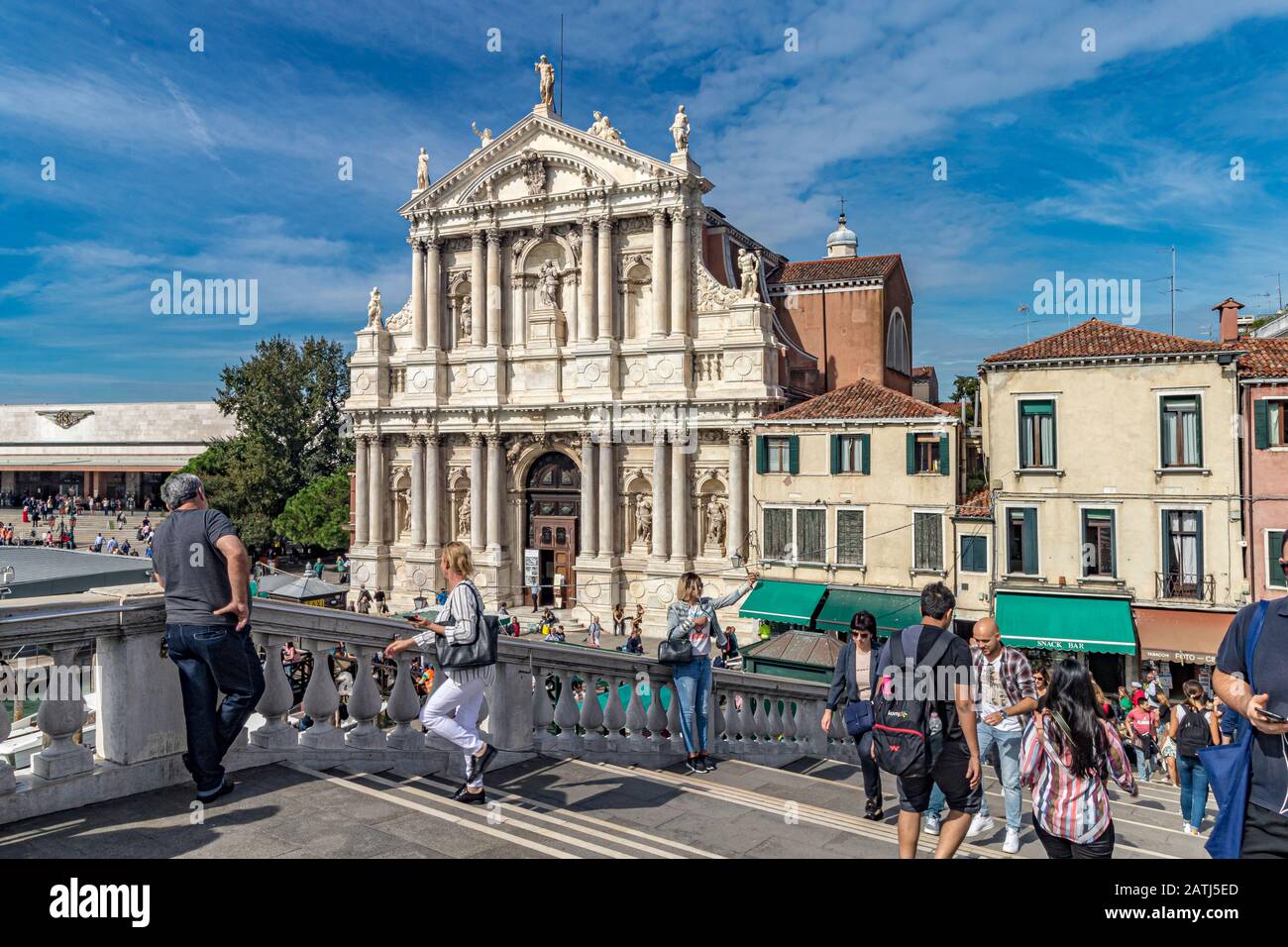 Menschen auf der Scalzi-Brücke mit dem äußeren der Kirche Santa Maria di Nazareth, die zum Canal Grande in der Nähe des Bahnhofs Santa Lucia, Venedig, Italien, führt Stockfoto