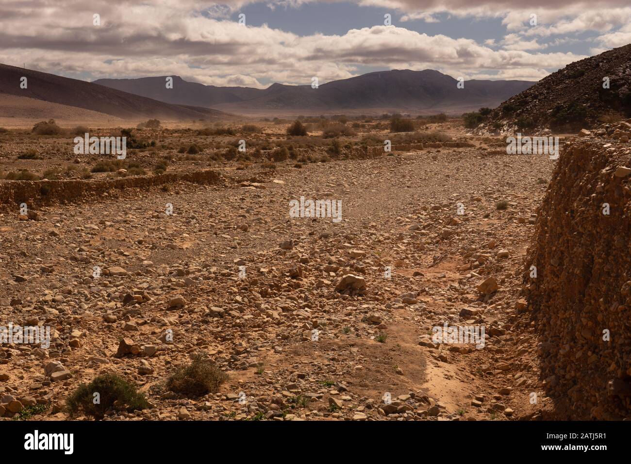Die Wüste im Süden von marokko, eine Bergkette hinter einem Tal Stockfoto