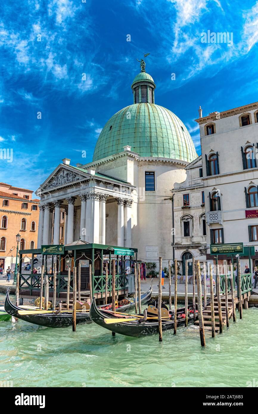 Leere Gondeln, die auf Holzstützen an einer Gondelstation vor Chiesa di San Simeon Piccolo auf dem Canal Grande in Venedig, Italien, festgemacht wurden Stockfoto