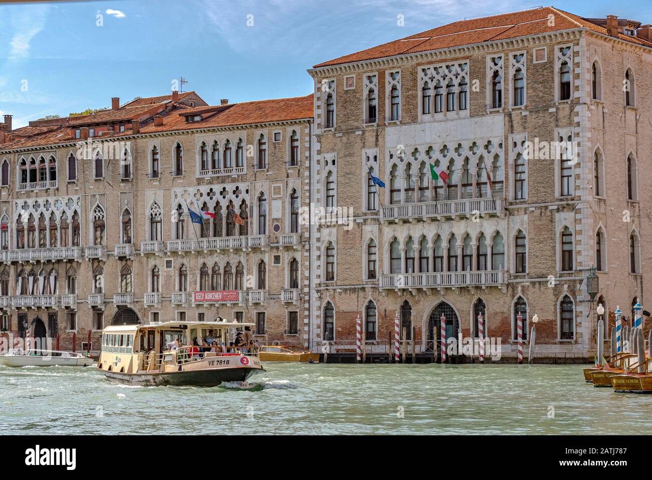 Eine Route Nr. 2 Vaporetto oder ein Wasserbus, der an Ca' Foscari und dem Palazzo Giustinian am Canal Grande in Venedig, Italien vorbeiführt Stockfoto